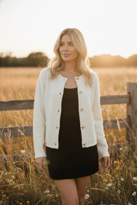 White scalloped trim long sleeve button down cardigan with black dress