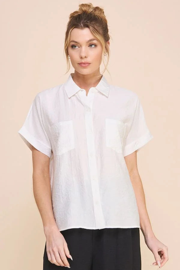 Woman in a textured short sleeve button front shirt with hair in a bun