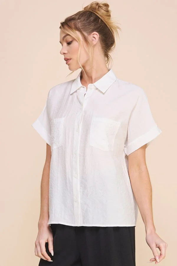 White textured short sleeve button front shirt worn by a woman with blonde hair