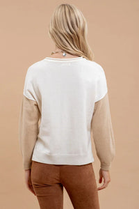 White short-sleeved sweater worn by a person with long blonde hair in colorblock style