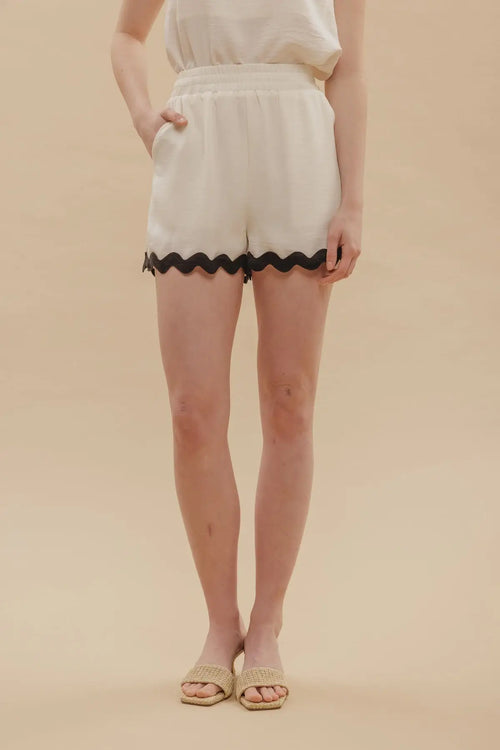White shorts with contrast wavy hem and black scalloped trim for stylish summer wear