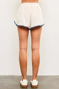 White shorts with blue trim featuring a rope elastic waist for comfortable fit