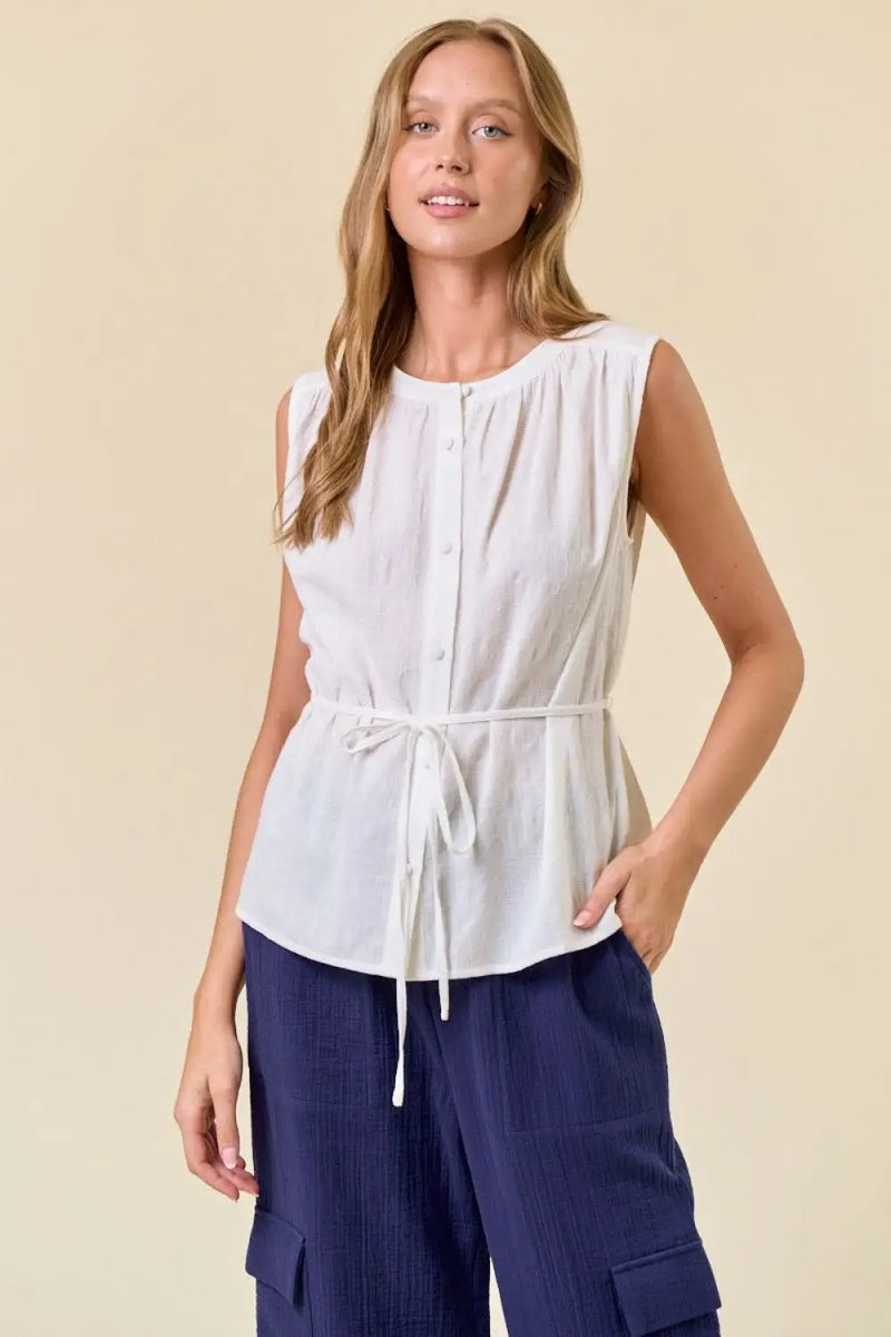White sleeveless button-down top with tie waist, ideal for women’s boho chic clothing from Shop Daisy