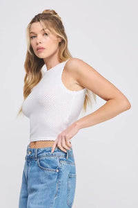 White sleeveless soft scallop edges crop top styled with light blue denim jeans