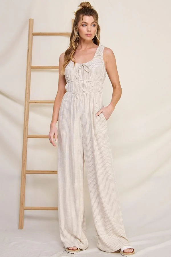 White sleeveless jumpsuit with tie-front bodice and wide-leg pants in pinstripe linen blend