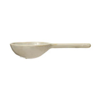 White spoon with handle, featured in the STONEWARE STRAINER SPOON design