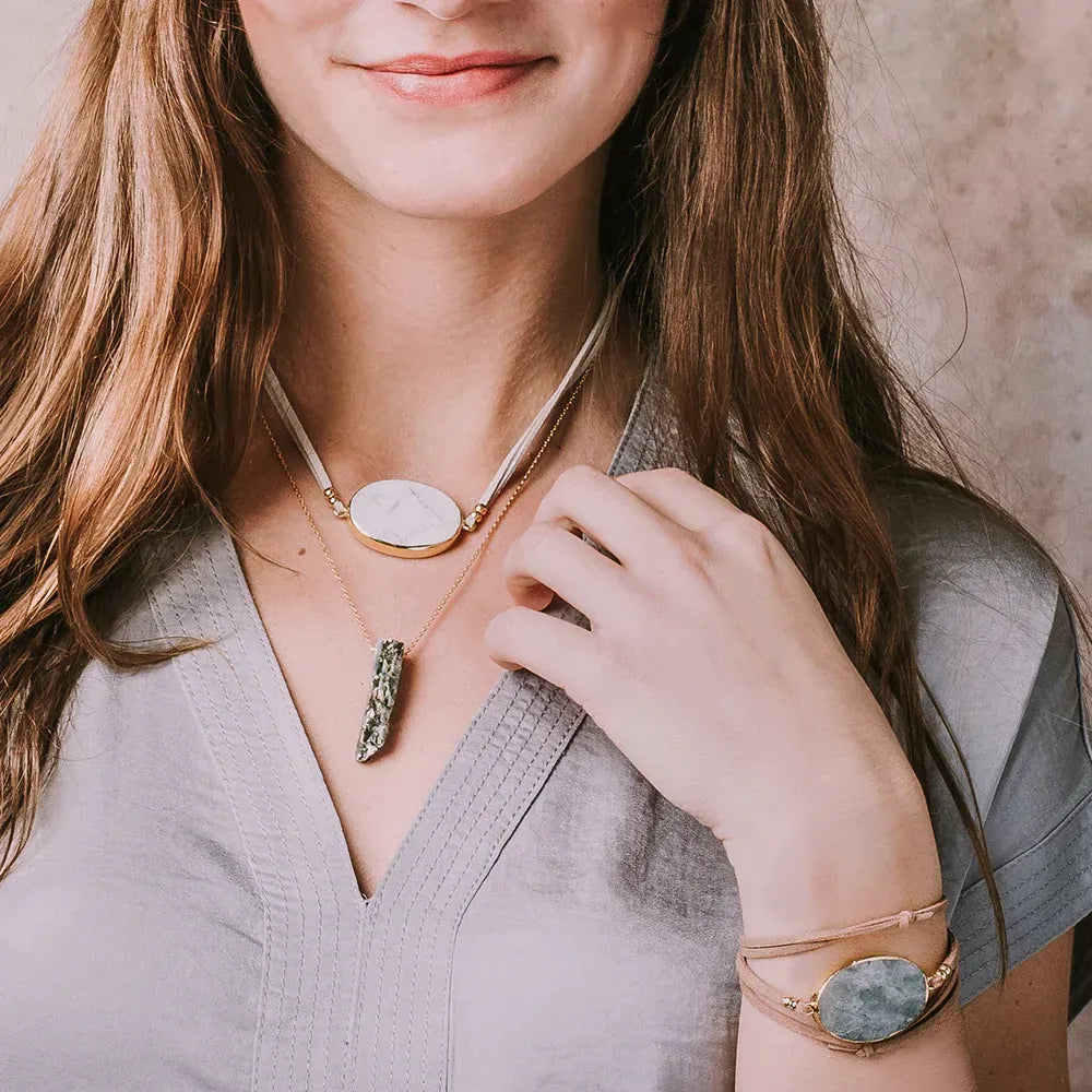 White stone pendant necklace with gold chain and green druzy accents