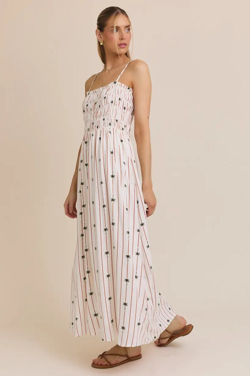 White striped smocked maxi dress adorned with palm tree print, perfect for summer wear