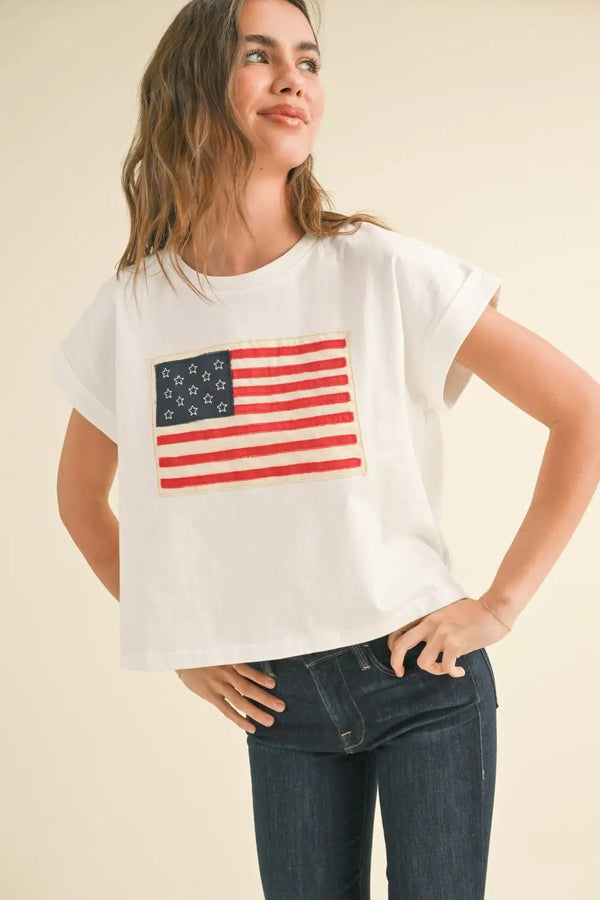 White t-shirt featuring American flag design from Shop Daisy’s women’s boho chic clothing