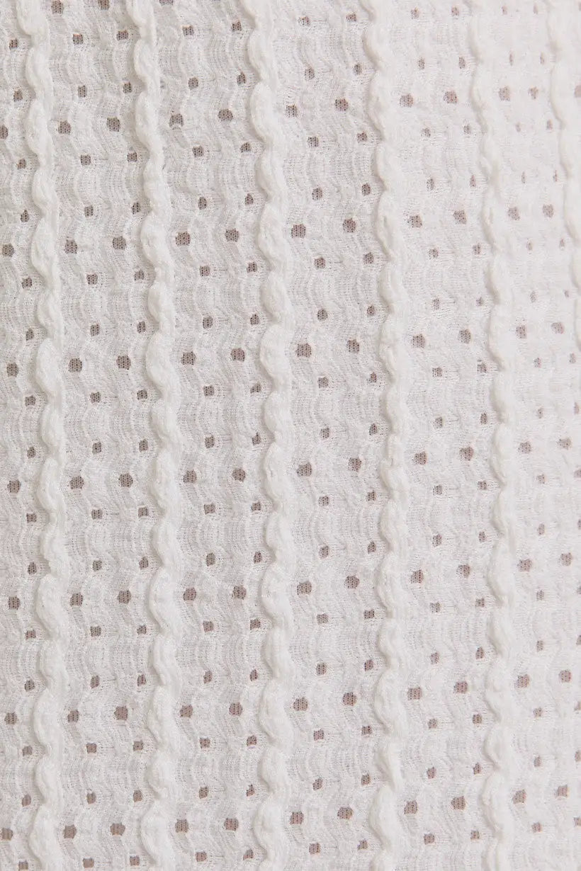 White textured fabric with small dots for surplice sleeveless waist tie eyelet midi dress