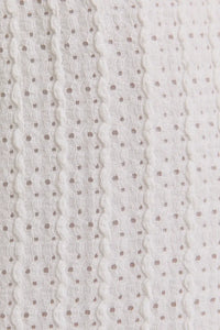 White textured fabric with small dots for surplice sleeveless waist tie eyelet midi dress