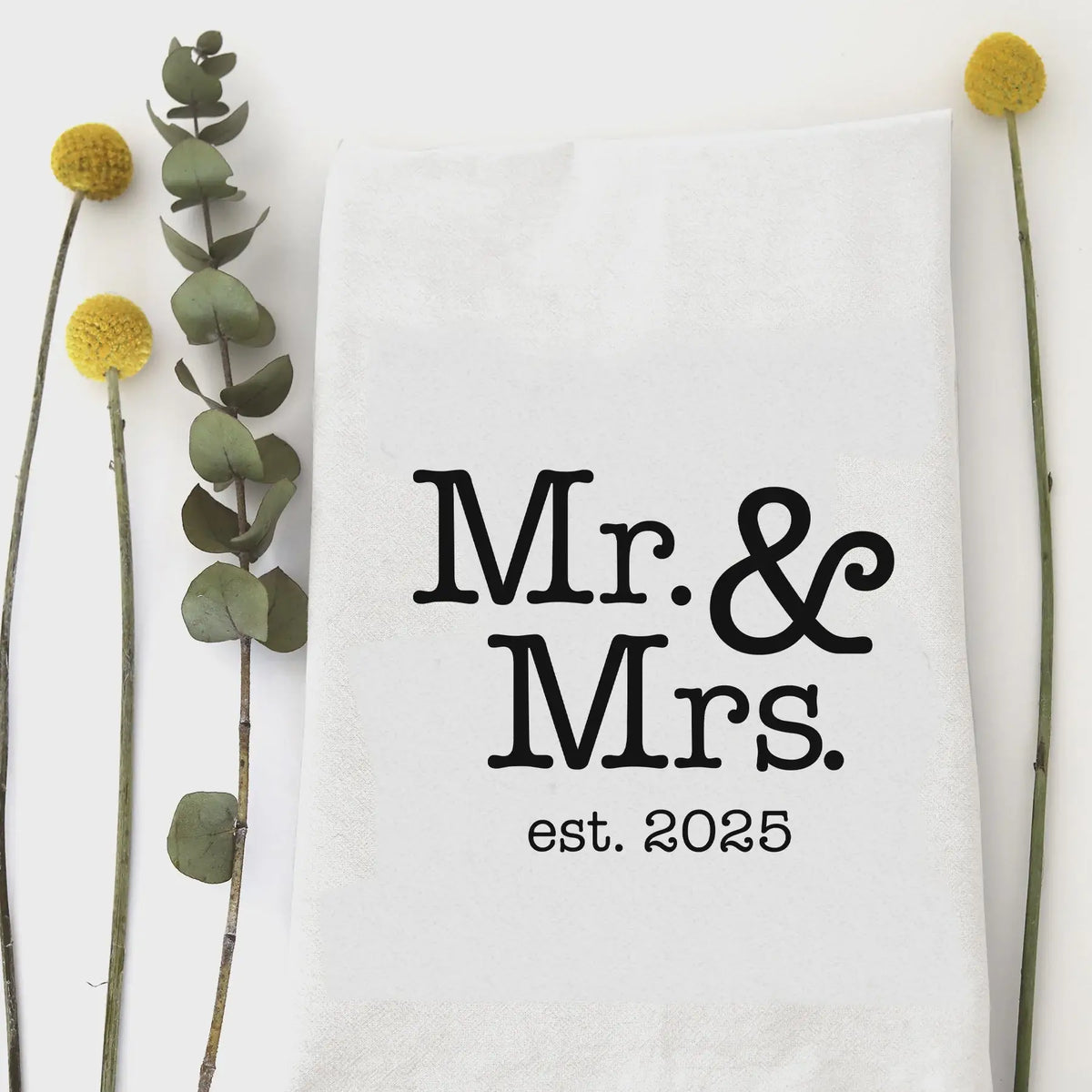 White tea towel featuring Mr. & Mrs. est. 2025, ideal for weddings and women’s boho chic clothing