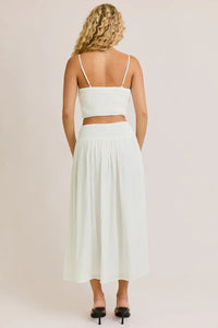 White two-piece skirt set featuring a smocked spaghetti strap crop top from Daisy Lane Offers