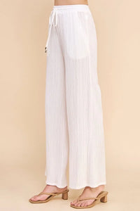 White wide-leg pants with adjustable tie waist in textured woven design