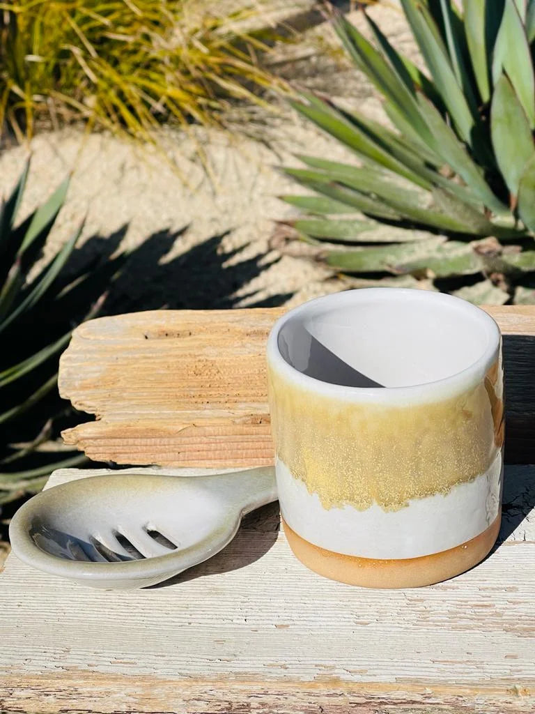 A white and yellow tea mug cup on a wooden table, featured in a cup & saucer set