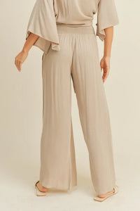 Wide-leg beige rayon smocked waist pants with high waist and flowing fabric