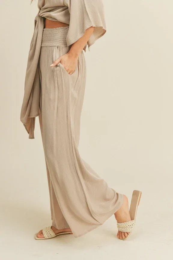 Wide-leg beige rayon smocked waist pants with side pockets and a flowing silhouette