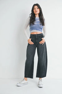 Wide leg black wash jeans styled with a blue crop top and white sneakers for a modern look