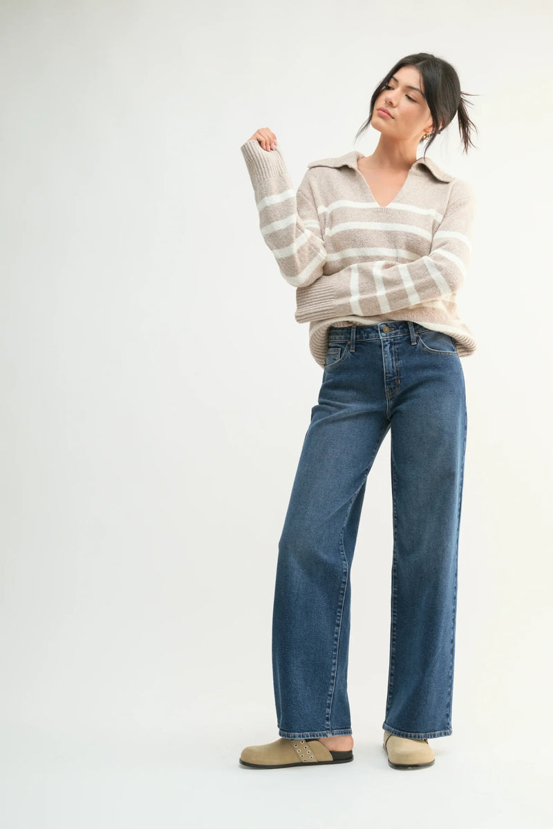 Wide-leg blue jeans styled with a striped sweater and casual shoes for a chic look