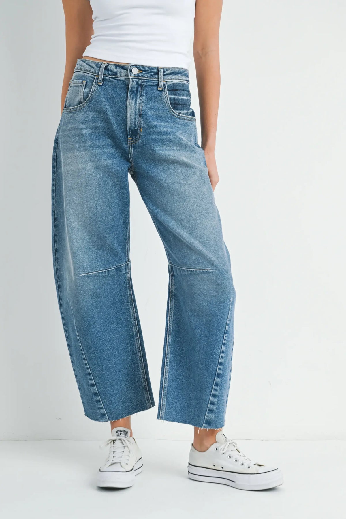 Wide-leg blue denim jeans paired with white sneakers in a stylish outfit
