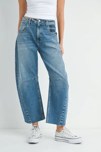 Wide-leg blue denim jeans paired with white sneakers in a stylish outfit