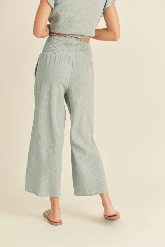 Wide-leg, high-waisted pale green trousers with double gauze smocking waist design