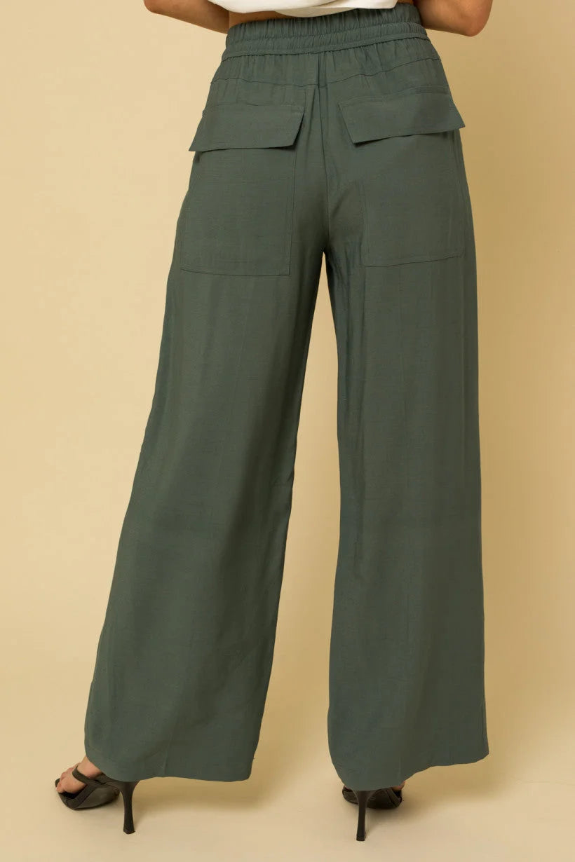 Wide leg olive green track pants with cargo-style pockets on the front