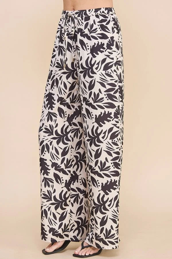 High waisted wide leg pants in black and white leaf print satin design