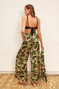 Wide-leg tropical print pants featuring a leafy green and brown pattern, perfect for island wear