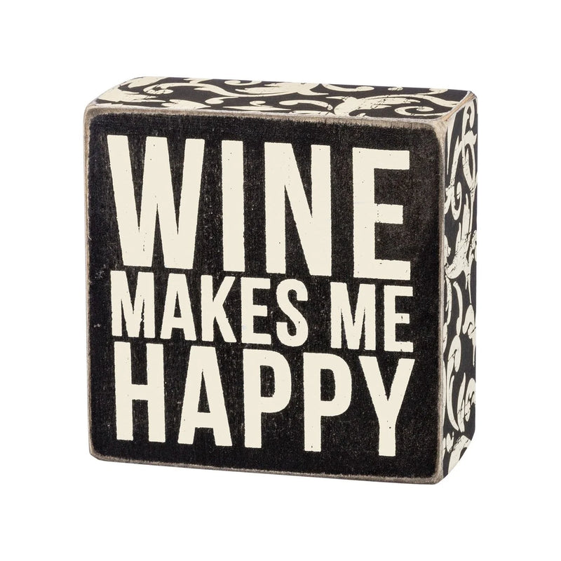 Happy box sign features the phrase wine makes me happy in a decorative design