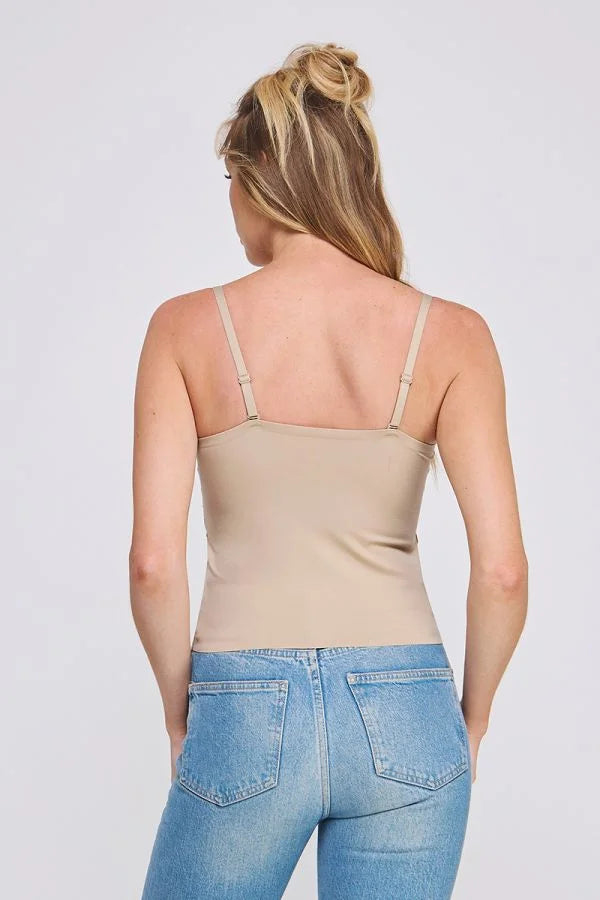 Woman wearing a beige bralette cami and blue jeans, perfect for women’s boho chic clothing from Shop Daisy