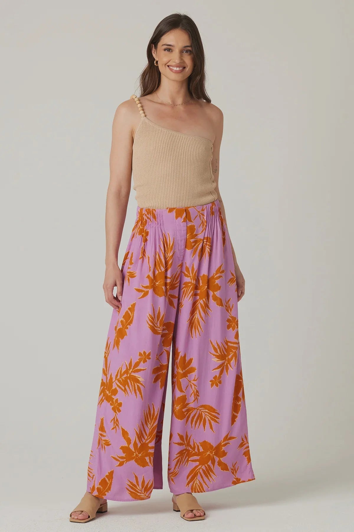 Woman in beige top and colorful floral palazzo pants, showcasing boho wide leg style