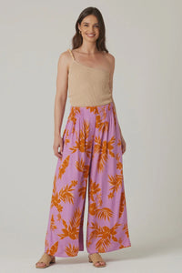 Woman in beige top and colorful floral palazzo pants, showcasing boho wide leg style