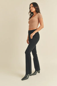 Woman in beige top and dark flared pants exuding a free spirit vibe in SLIM BOOTCUT