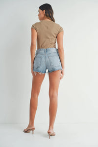 Woman in a beige top and denim shorts, embodying boho style in RELAXED SHORT