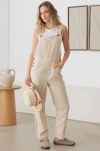 Woman in flowy beige linen overalls showcasing a boho style from BUTTON DETAIL OVERALL JUMPSUIT