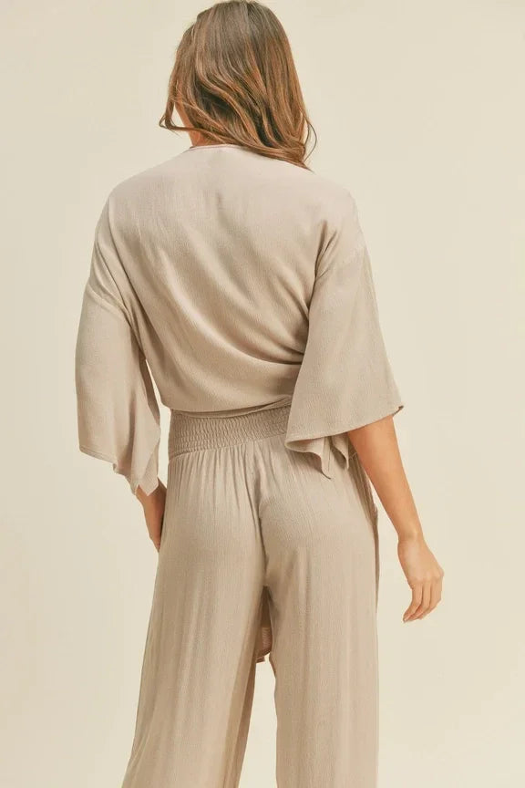 Woman in beige rayon tied front top and wide-leg pants, showcasing boho flowy style