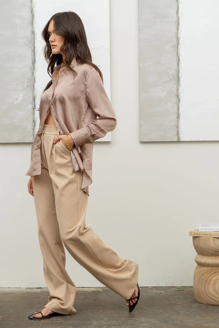 Woman in beige wide-leg pants and loose cardigan with a stylish pinstripe button top