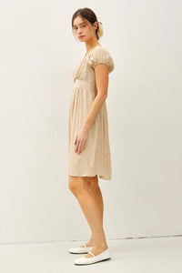 Woman wearing a floral print mini dress with puff sleeves and white ballet flats