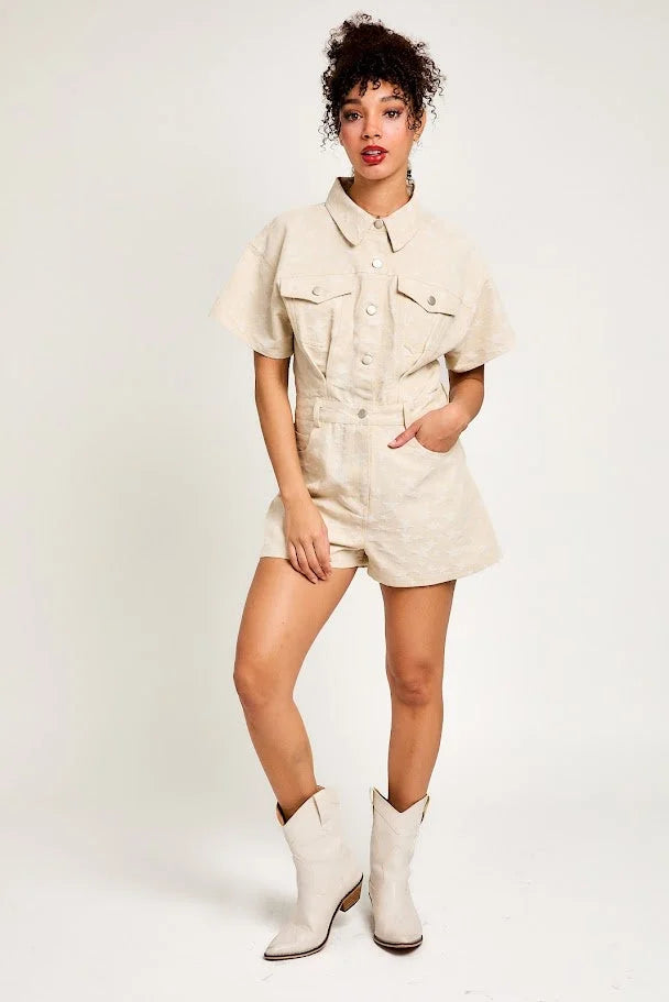 Woman in beige short-sleeved romper and white cowboy boots from Shop Daisy women’s boho chic clothing