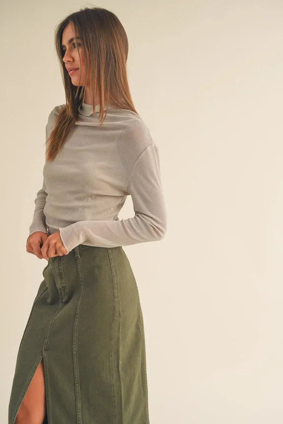 Woman in beige sweater and olive green side slit skirt from Shop Daisy women’s boho chic clothing