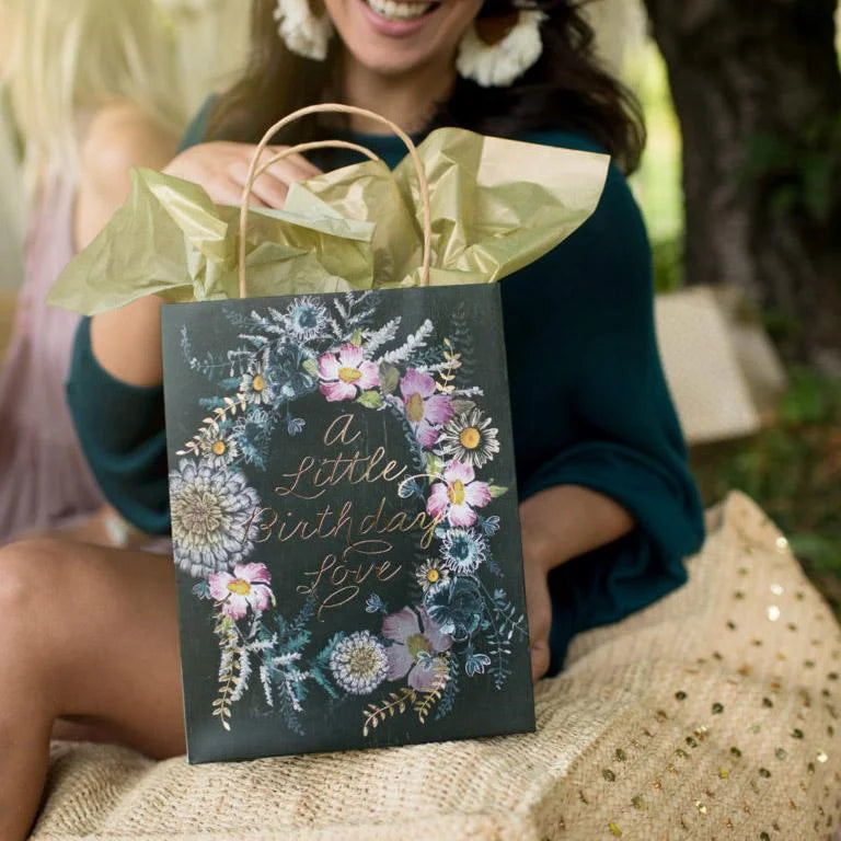 Woman holding a floral black bag from the Daisy Lane Birthday Love gift bags collection