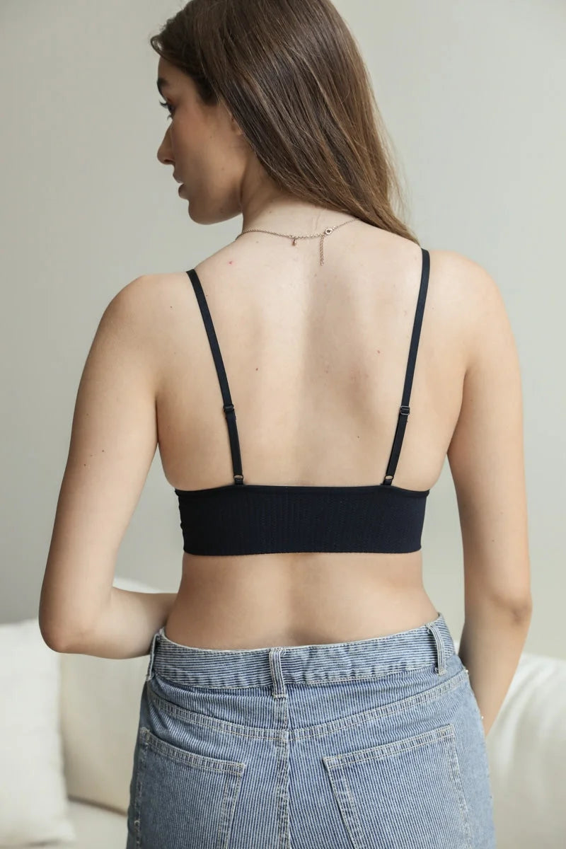 Woman in a black bra top and jeans, showcasing the Waistband Loop Lace Seamless Brami