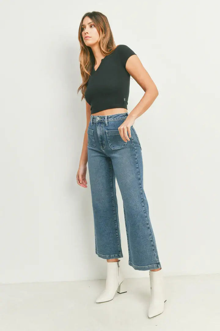 Woman in black crop top and white boots showcasing women’s boho chic sailor pocket wide leg jeans