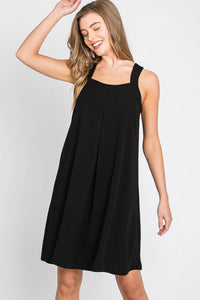 Woman showcasing a stylish solid spaghetti strap dress in elegant black