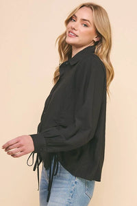 Woman in a black jacket and blue jeans showcasing a Woven Button Up with Princess Seam