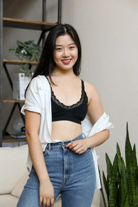 Woman in a black top and jeans showcasing feminine elegance with a lace trim padded bralette