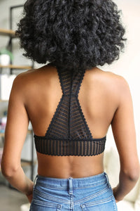 Woman in a black top and jeans showcasing Ribbed Lace Boho Racerback Bralette