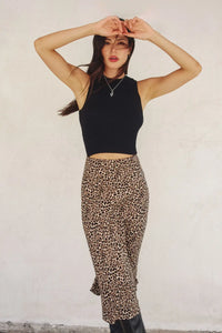 Woman in black top and leopard animal print midi skirt in size small