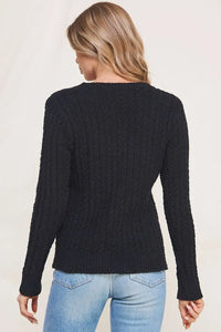 Woman wearing a black soft cloud ribbed V neck pullover sweater and blue jeans